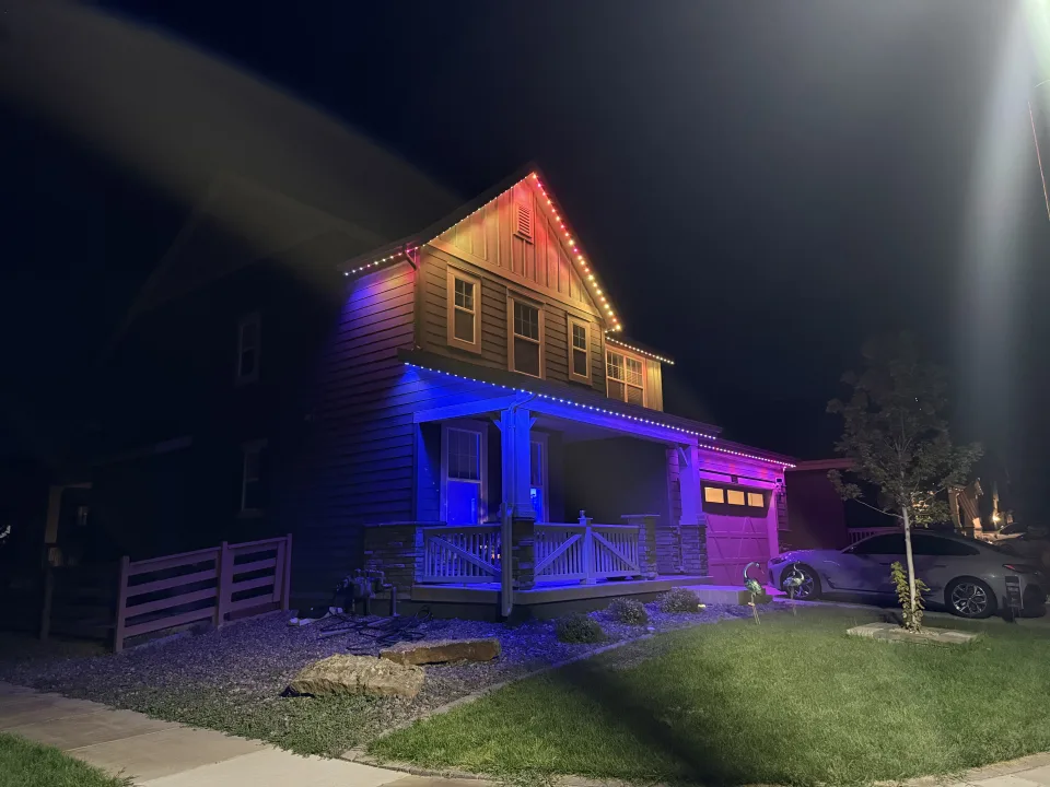 Home washed in vivid red permanent lighting against a deep blue evening sky
