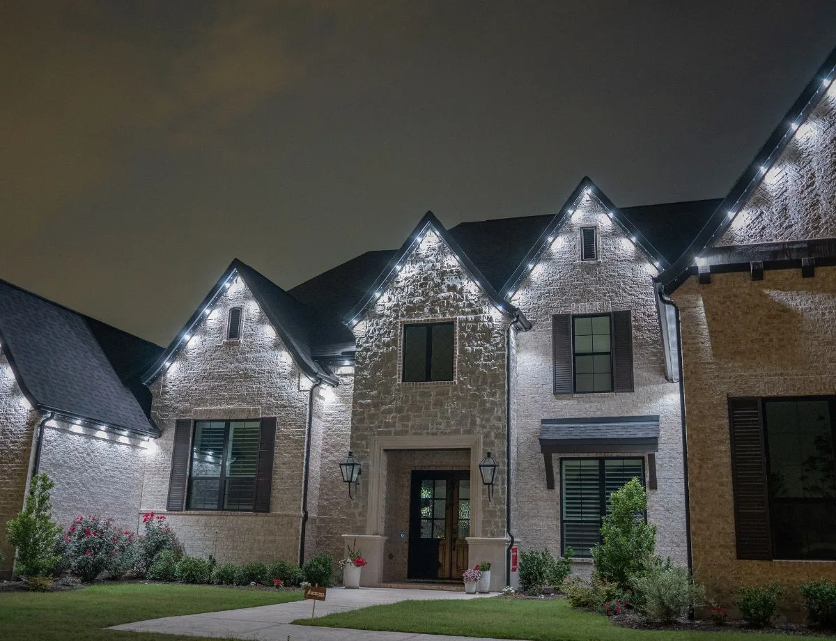 Permanent lighting tucked under the eaves of a home, seen from below at night