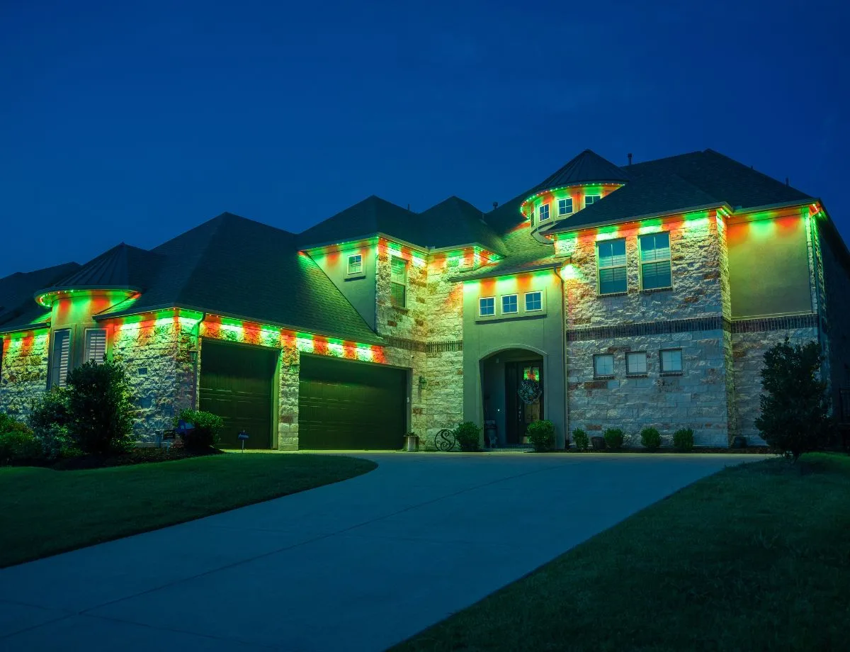 Home outlined in red and green permanent lighting at dusk