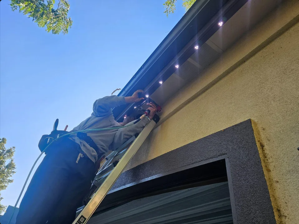 Residential exterior with permanent lighting running along every roofline after dark